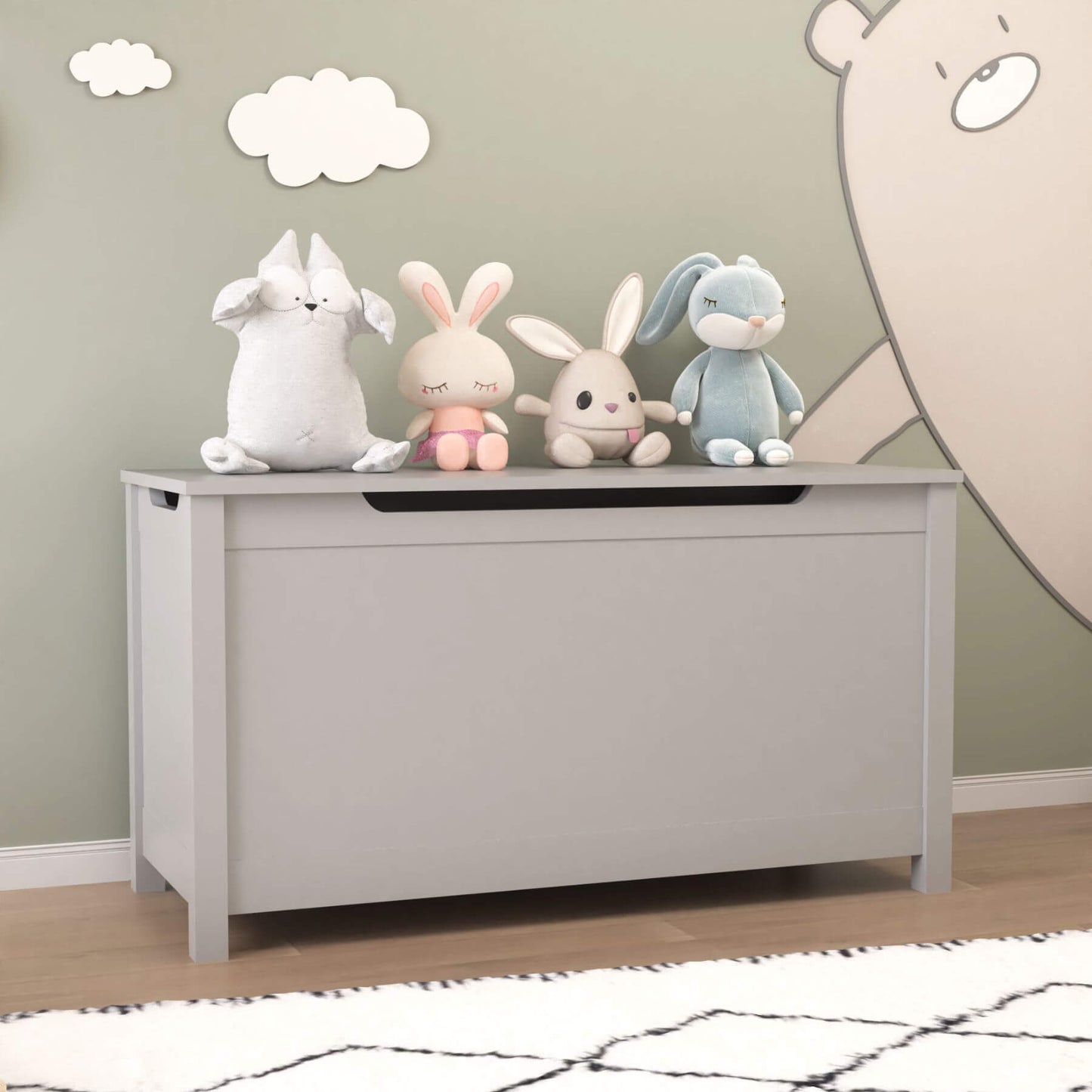 MOONRIVER Kids Wooden Toy Box Storage with Safety Hinged Lid - Grey with stuffed animals on a wooden floor against a wall with cloud decorations.