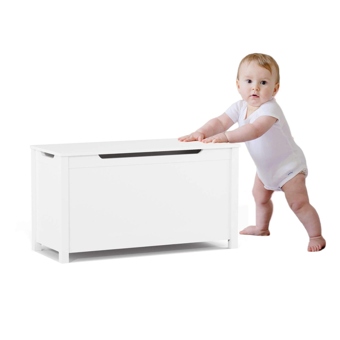 Baby in a white onesie standing next to MOONRIVER Kids Wooden Toy Box Storage with Safety Hinged Lid - White