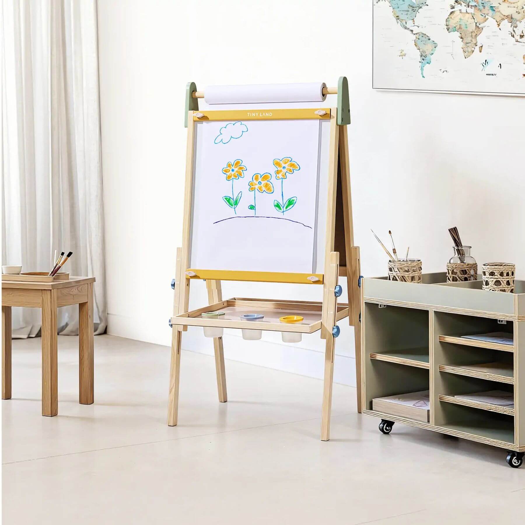 Tiny Land® 3-in-1 Art Easel for Kids - Morandi in a room with a table and storage unit.
