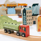 Wooden toy train set with a green leaf fuel car on a track, surrounded by small buildings and trees.