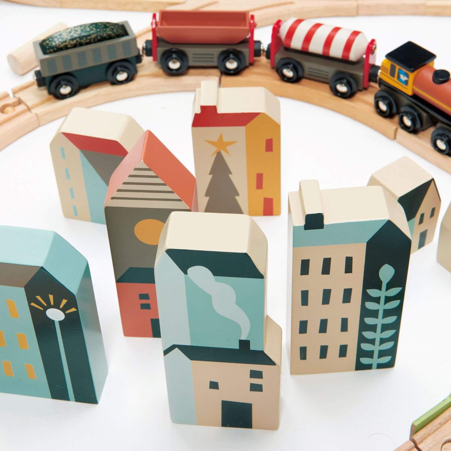 Wooden toy train set with colorful houses on a white background