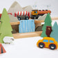 Wooden toy train set with trees, animals, and a car on a white background