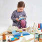 Child playing with Tender Leaf Mountain View Train Set on a white background