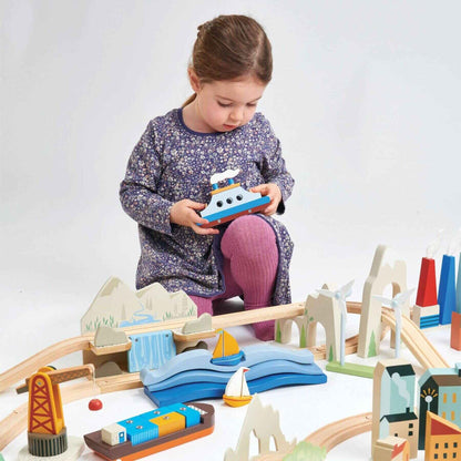 Child playing with Tender Leaf Mountain View Train Set on a white background
