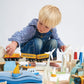 Child playing with Tender Leaf Mountain View Train Set on a white background