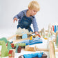 Child playing with Tender Leaf Mountain View Train Set on a white background