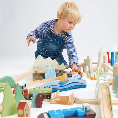 Child playing with Tender Leaf Mountain View Train Set on a white background