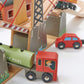 Wooden toy set with a fuel truck, car, and building structure on a white background