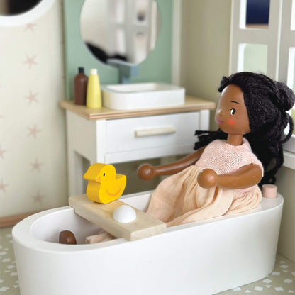 Toy bathtub with a doll and rubber duck in a bathroom setting