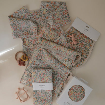 Floral-patterned baby outfit with accessories on a light background