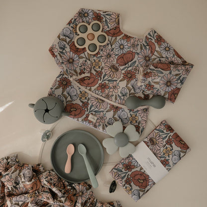 Floral-patterned baby outfit with accessories on a light background
