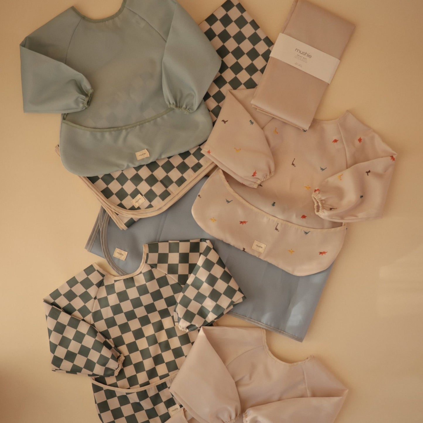 Collection of baby clothing and accessories on a beige background