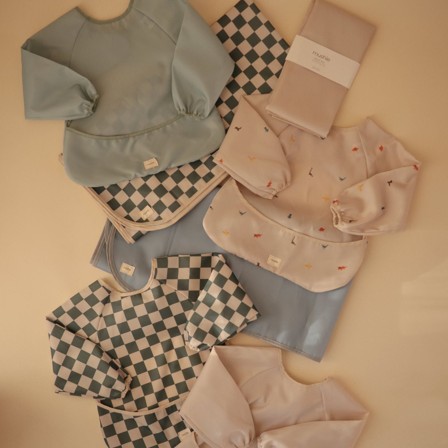 Collection of baby clothing and accessories on a beige background