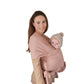 Woman holding a baby in Mushie Baby Wrap Blush against a white background