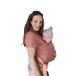 Woman holding a baby in Mushie Baby Wrap Cedar against a white background