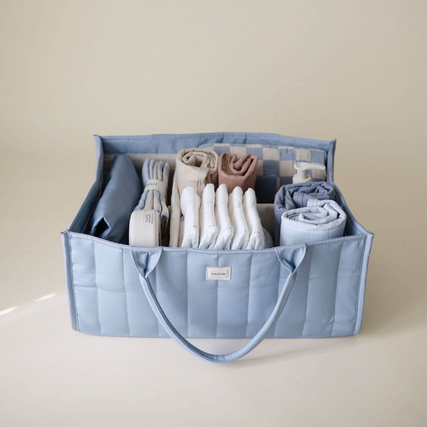 Mushie Diaper Caddy with baby items