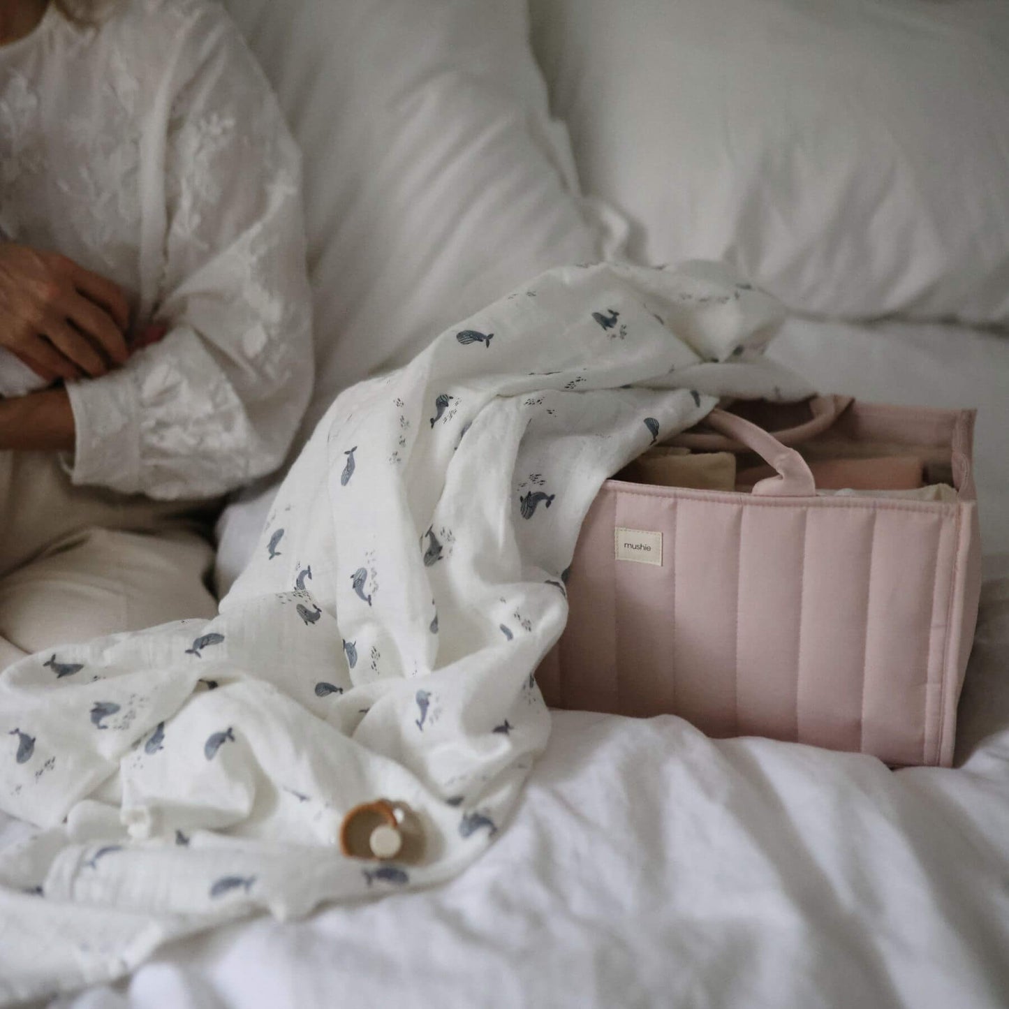 Mushie Diaper Caddy on a bed