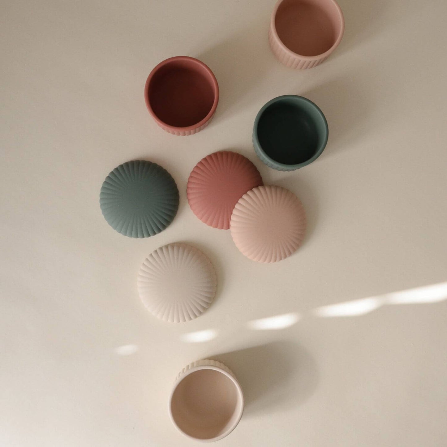 Mushie Silicone Baby Food Containers on a light surface