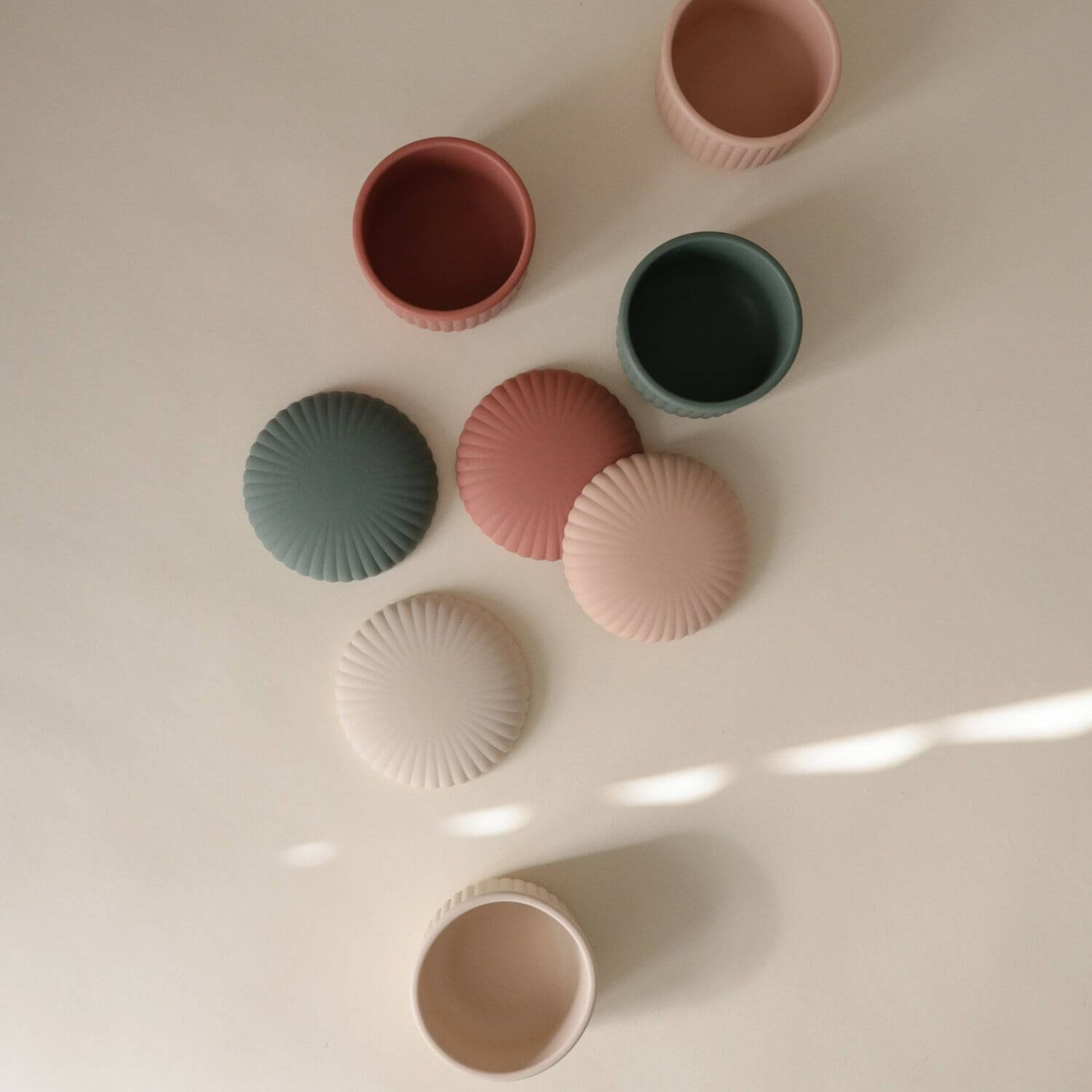 Mushie Silicone Baby Food Containers on a light surface