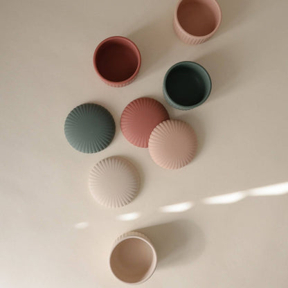 Mushie Silicone Baby Food Containers on a light surface