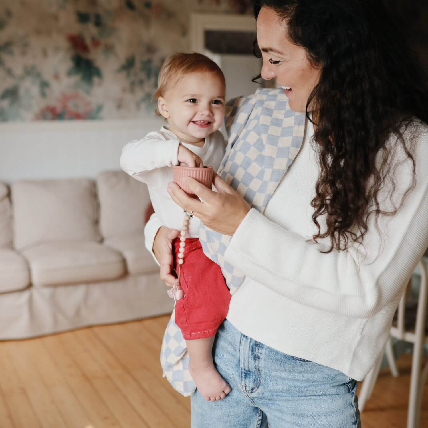 Woman holding a baby in a living room