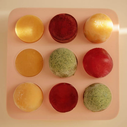 Nine colorful ice creams arranged in a Mushie Baby Food Freezer Tray
