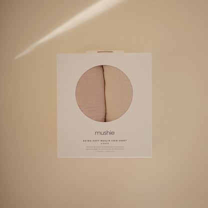 Mushie extra soft muslin crib sheet packaging on a beige background