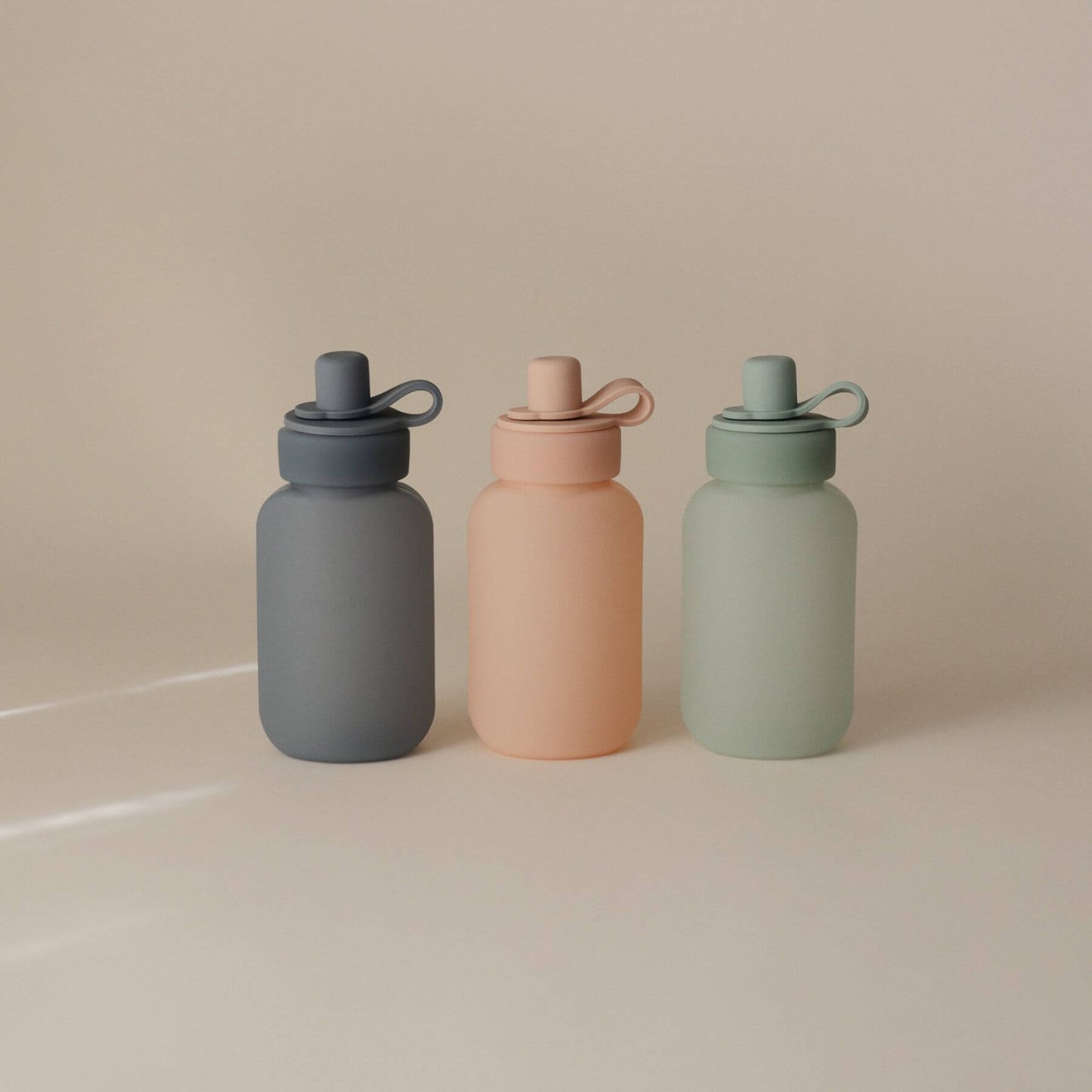 Three Mushie Silicone Puree Pouch on a beige background