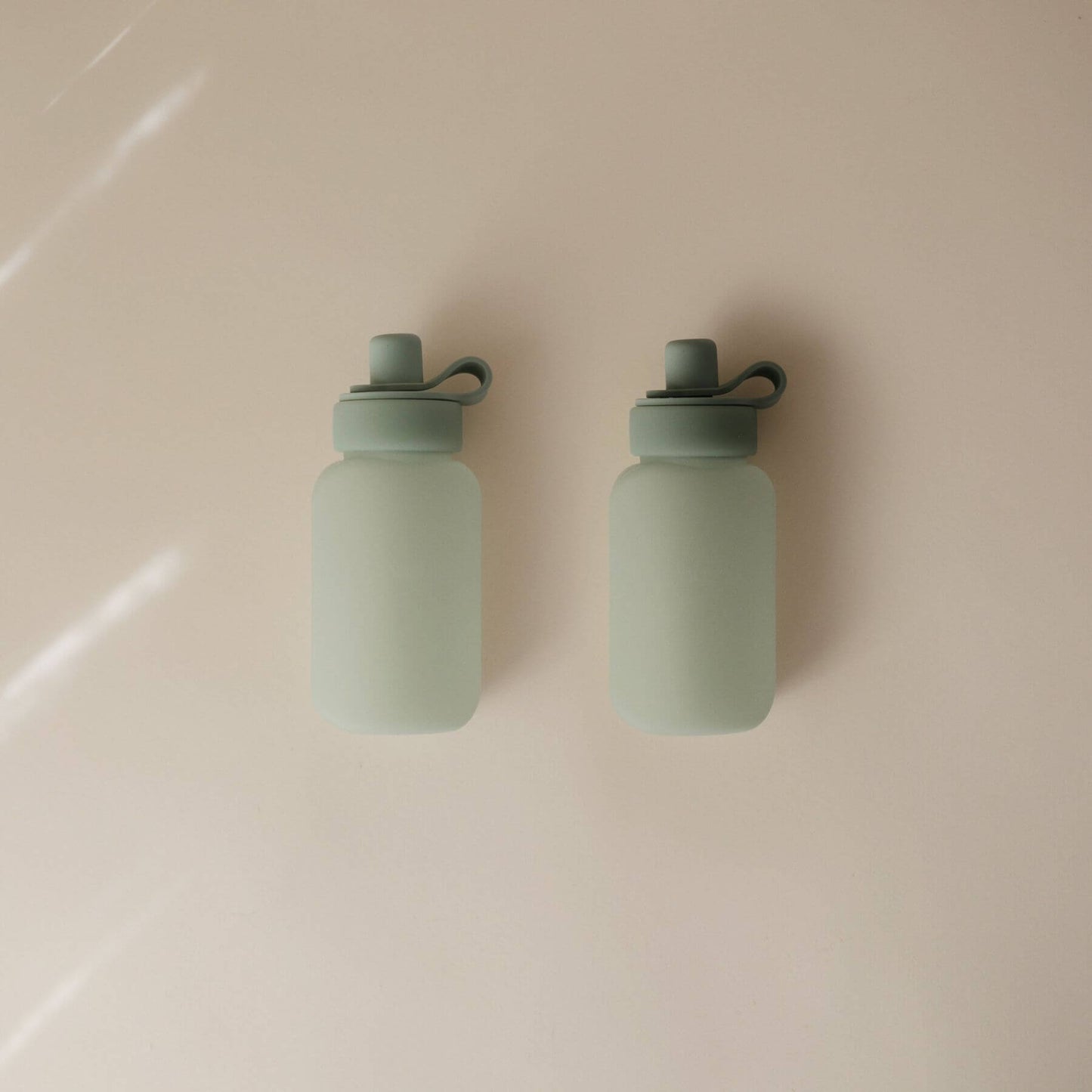Two Mushie Silicone Puree Pouch on a beige surface