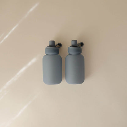 Two Mushie Silicone Puree Pouch on a beige surface