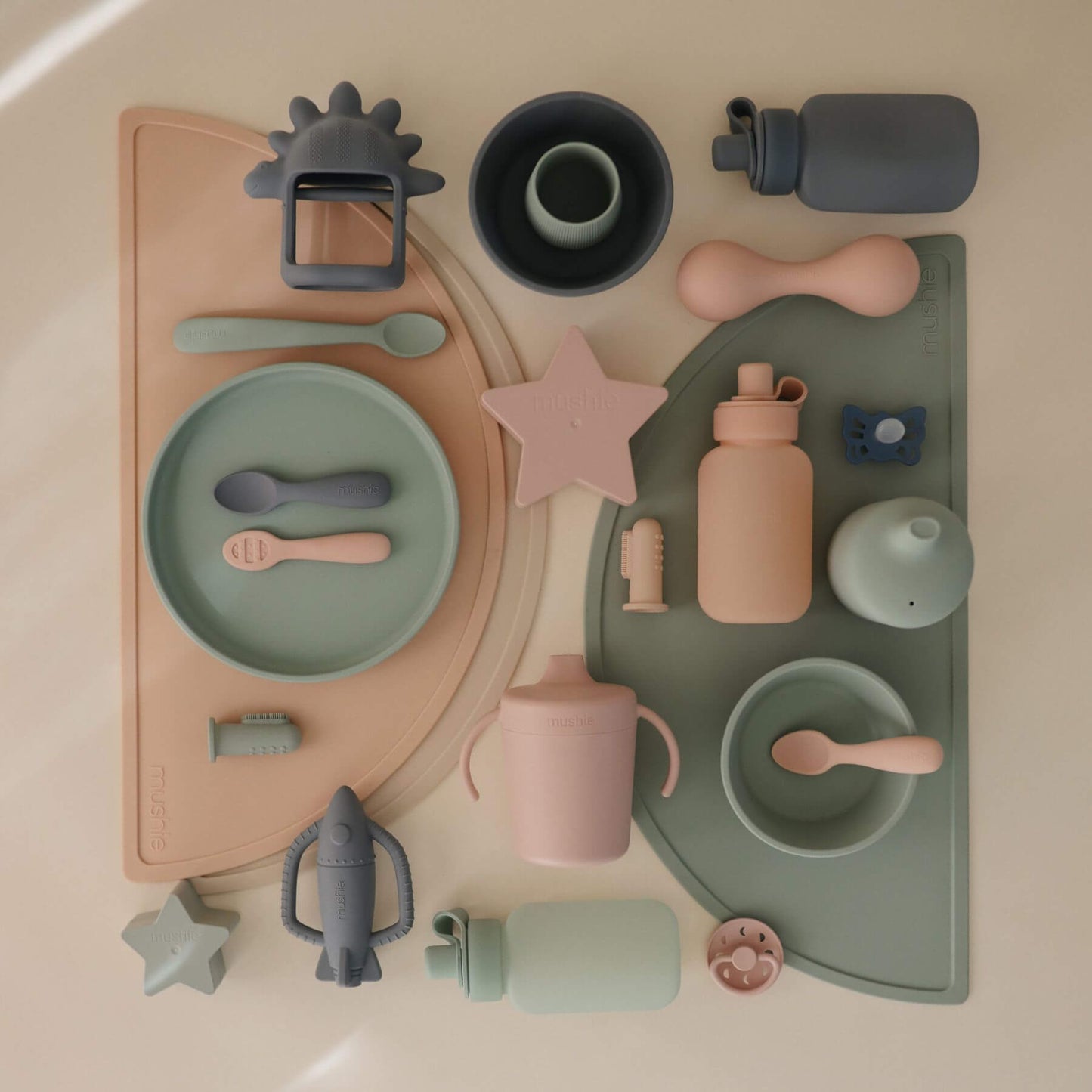 Collection of children's tableware and toys on a neutral background