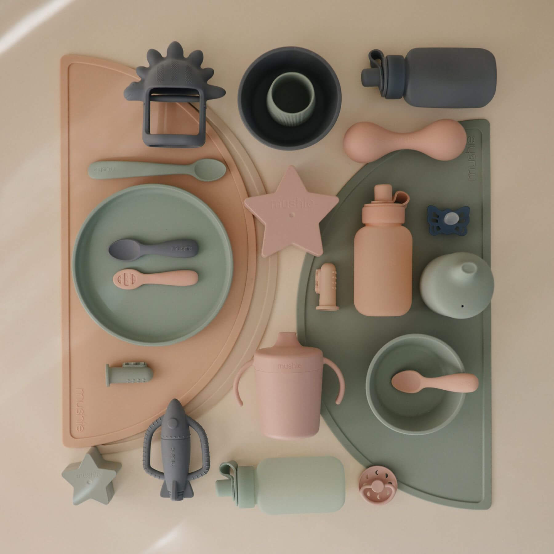 Collection of children's tableware and toys on a neutral background