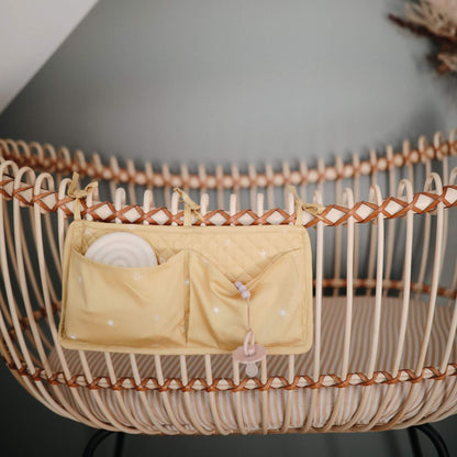 Wicker basket with a yellow pouch inside on a dark background