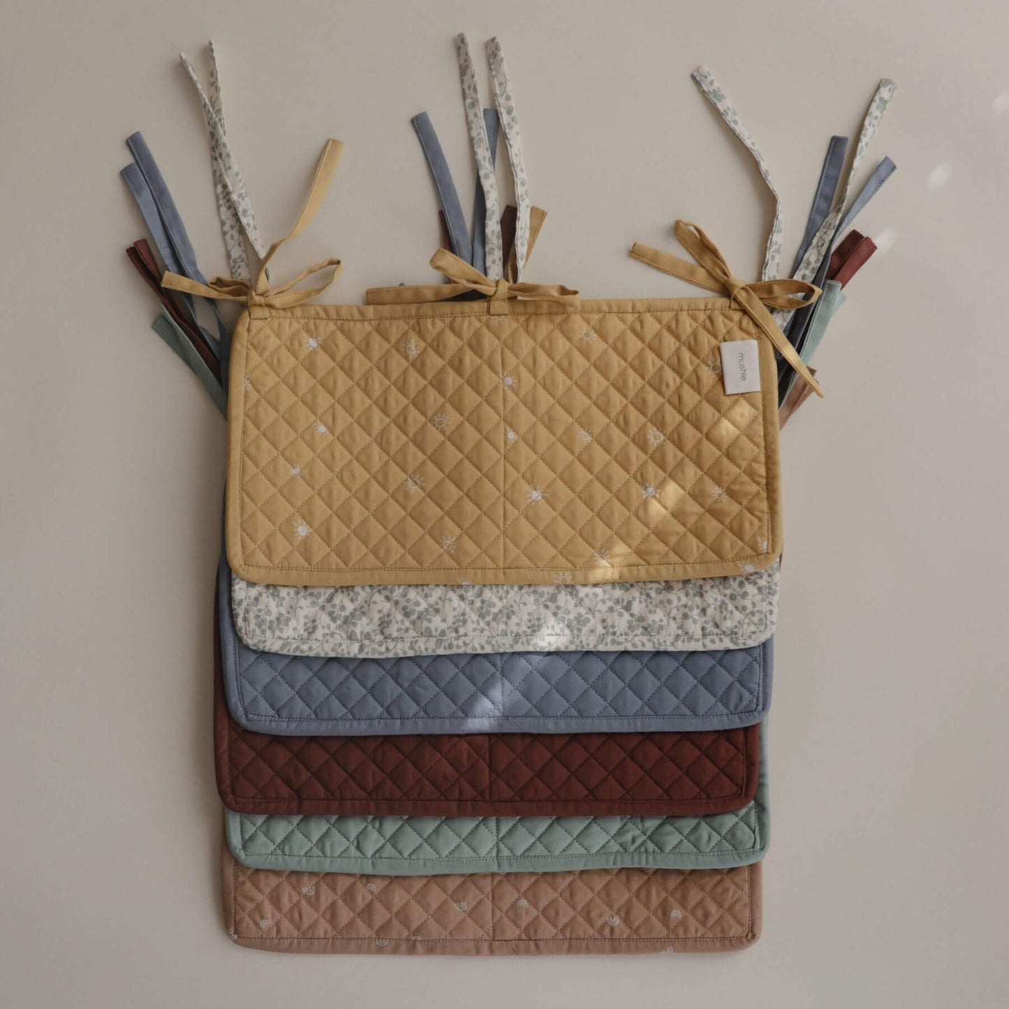 Stack of Mushie Storage Pocket various colors on a neutral background