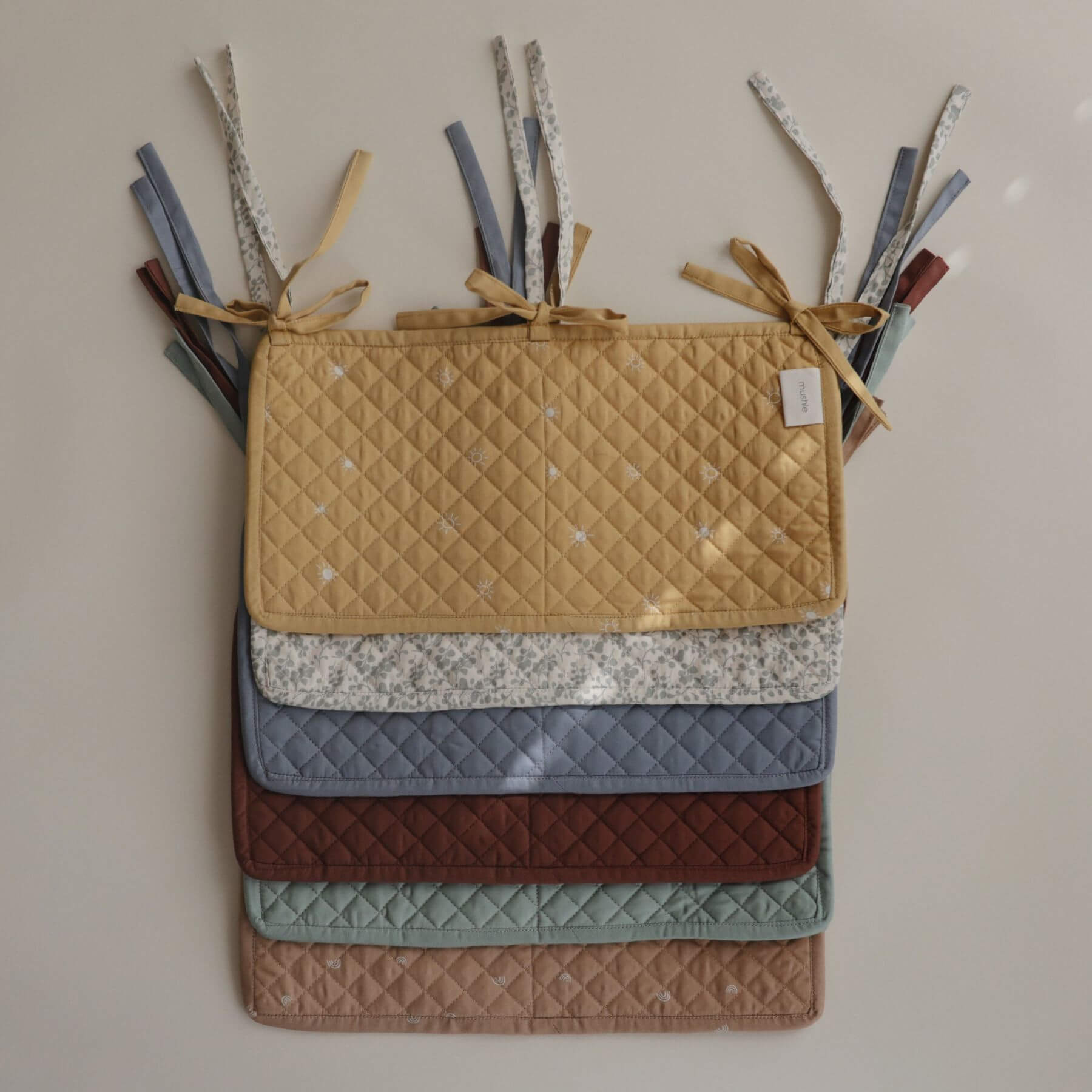 Stack of Mushie Storage Pocket various colors on a neutral background
