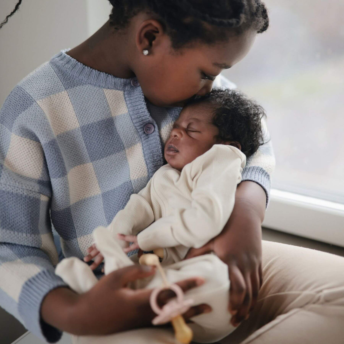 Woman holding a baby wearing Mushie Zipper Pajama - Ivory