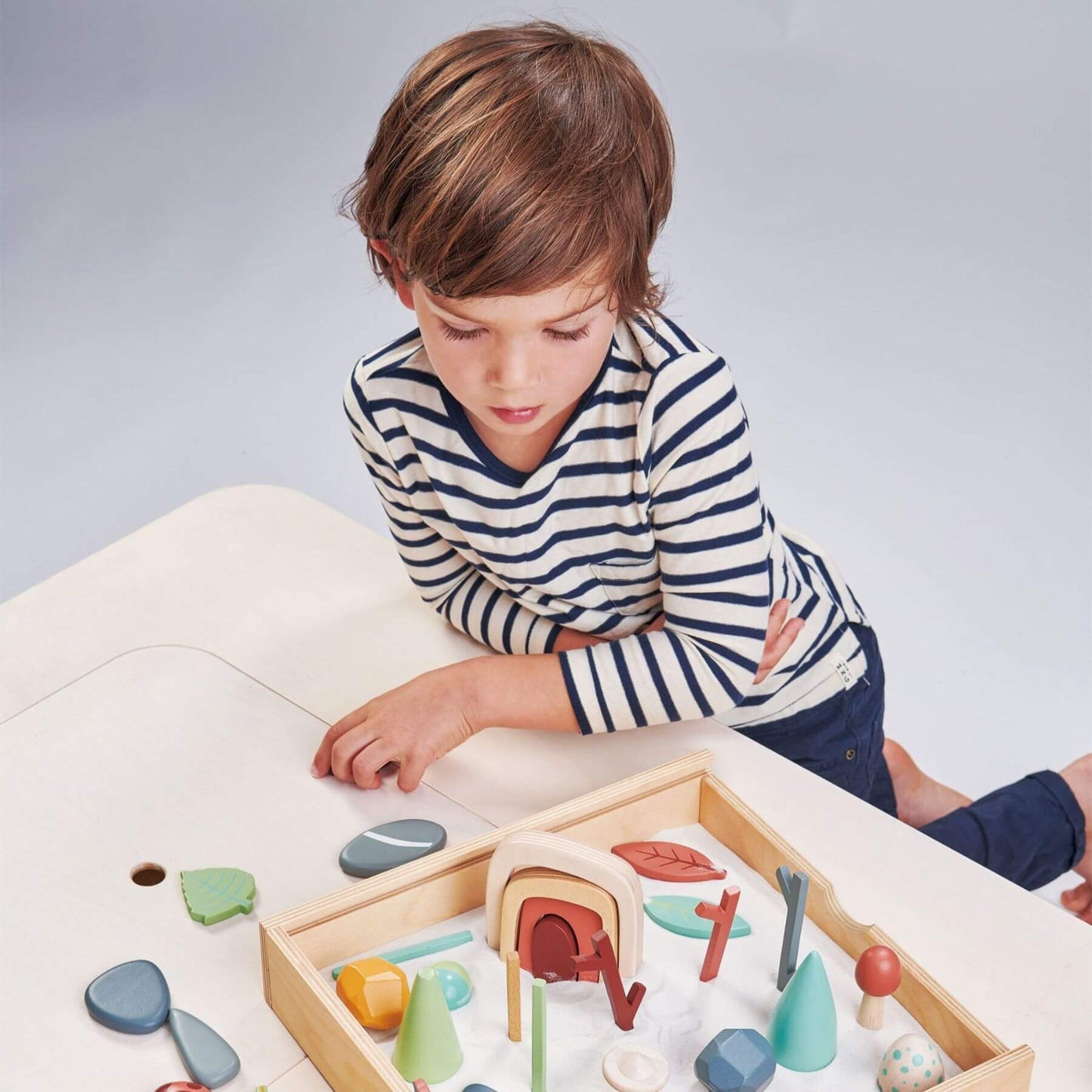 Child playing with Tender Leaf My Forest Floor on a light surface