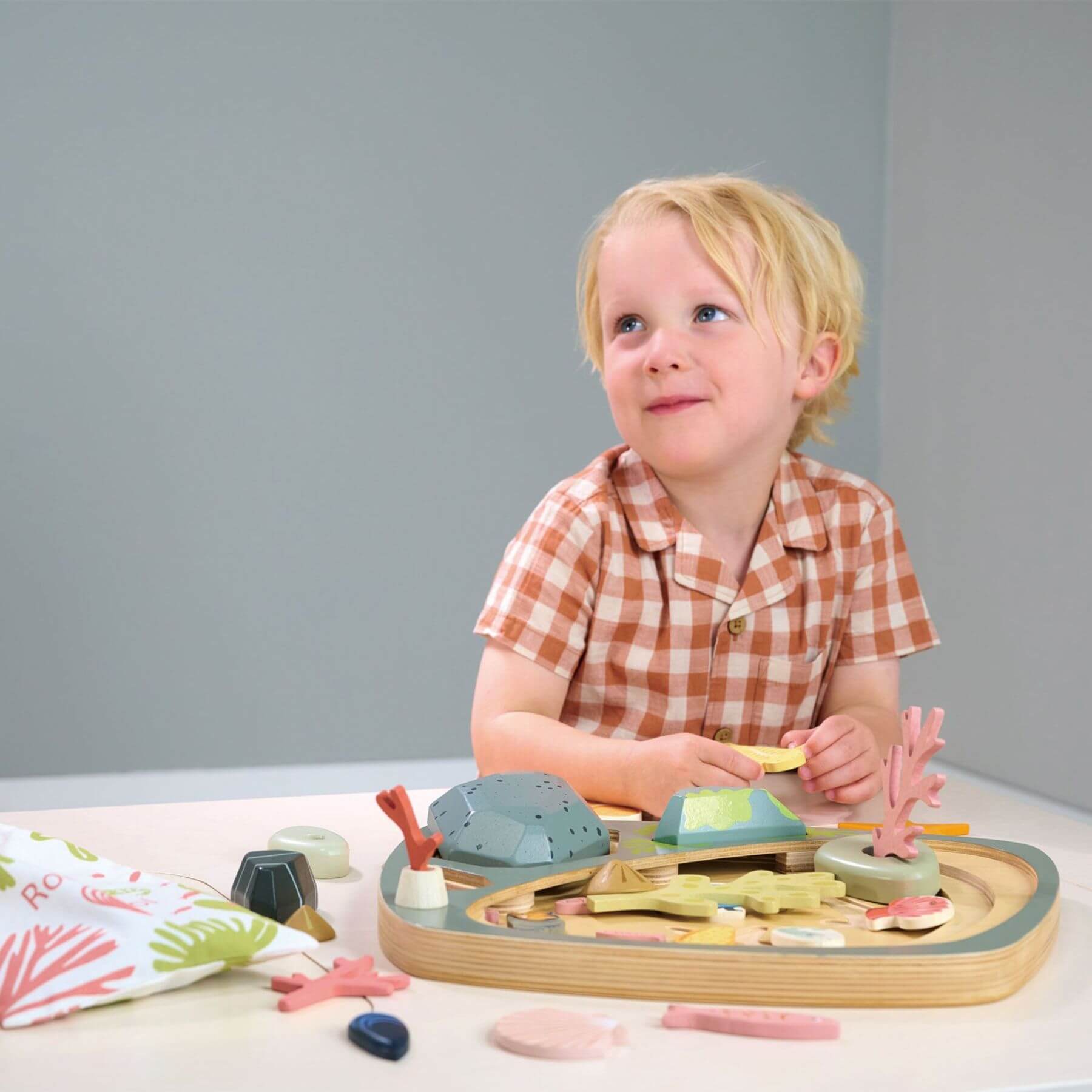 Child playing with Tender Leaf My Little Rock Pool on a table against a gray background