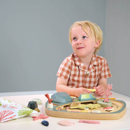 Child playing with Tender Leaf My Little Rock Pool on a table against a gray background