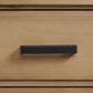 Black cabinet handle on a wooden drawer