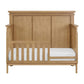 Wooden crib with white mattress on a white background