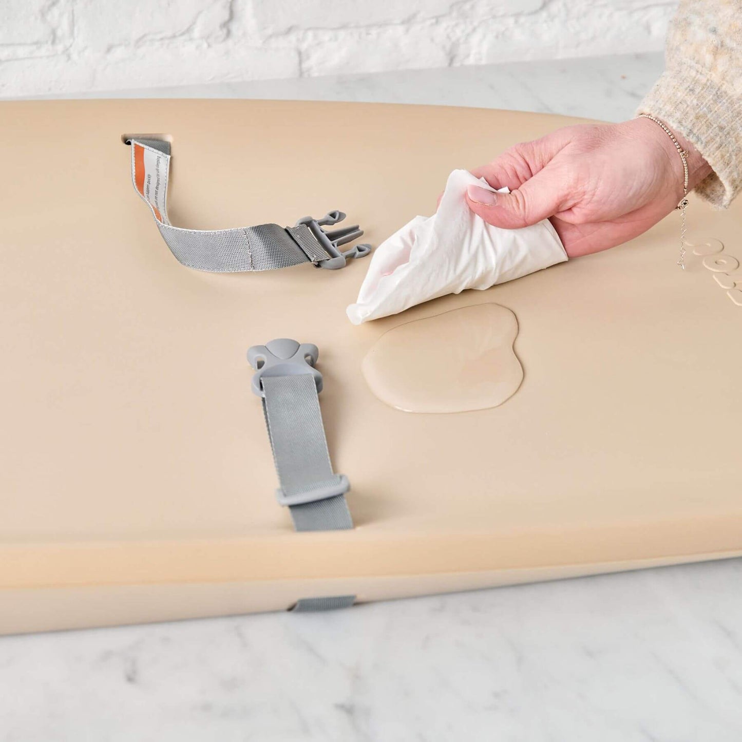 Person wiping water off Nattou Diaper Changing Pad Softy