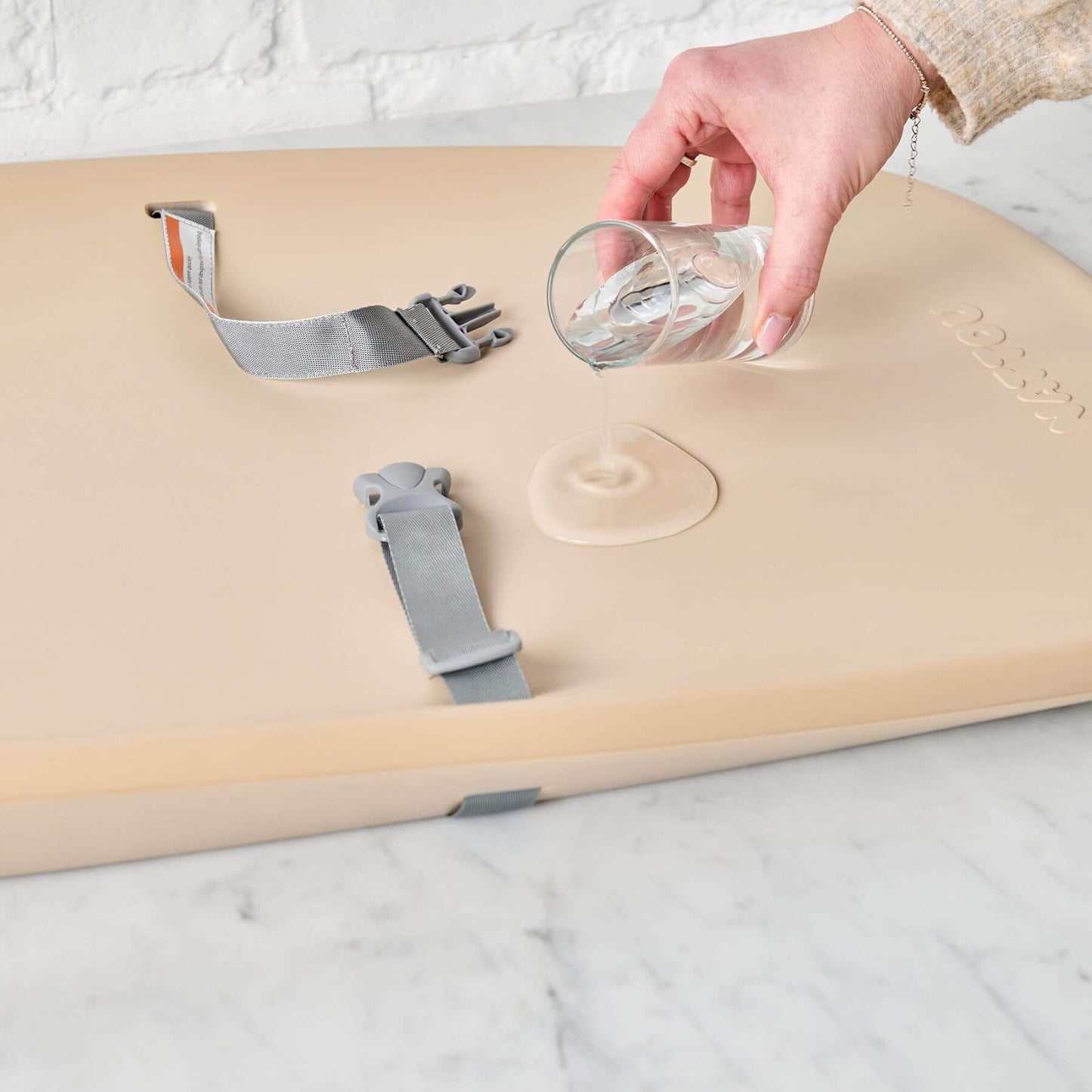 Person Pouring Water on Nattou Diaper Changing Pad Softy Beige