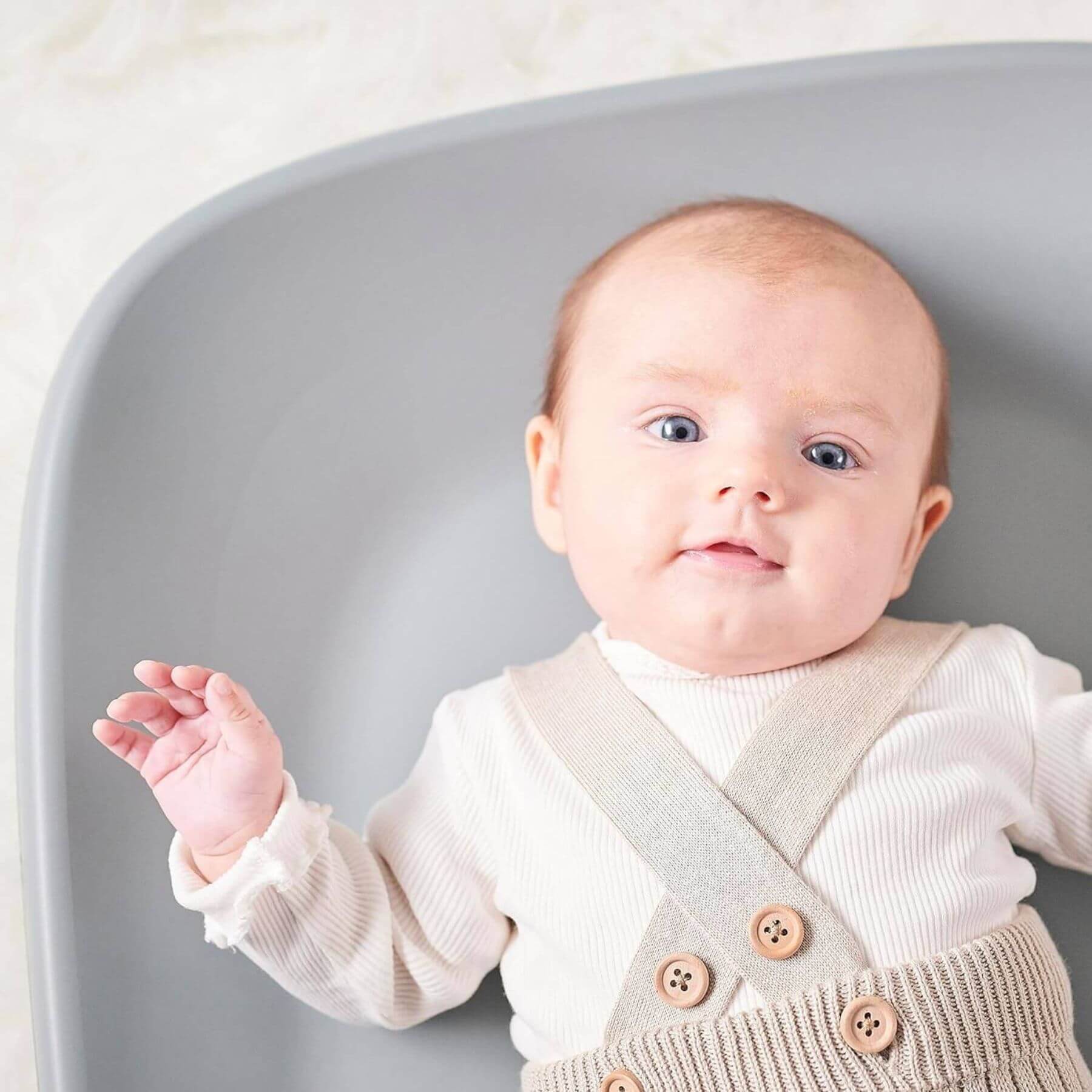 Baby lying on green Nattou Diaper Changing Pad Softy