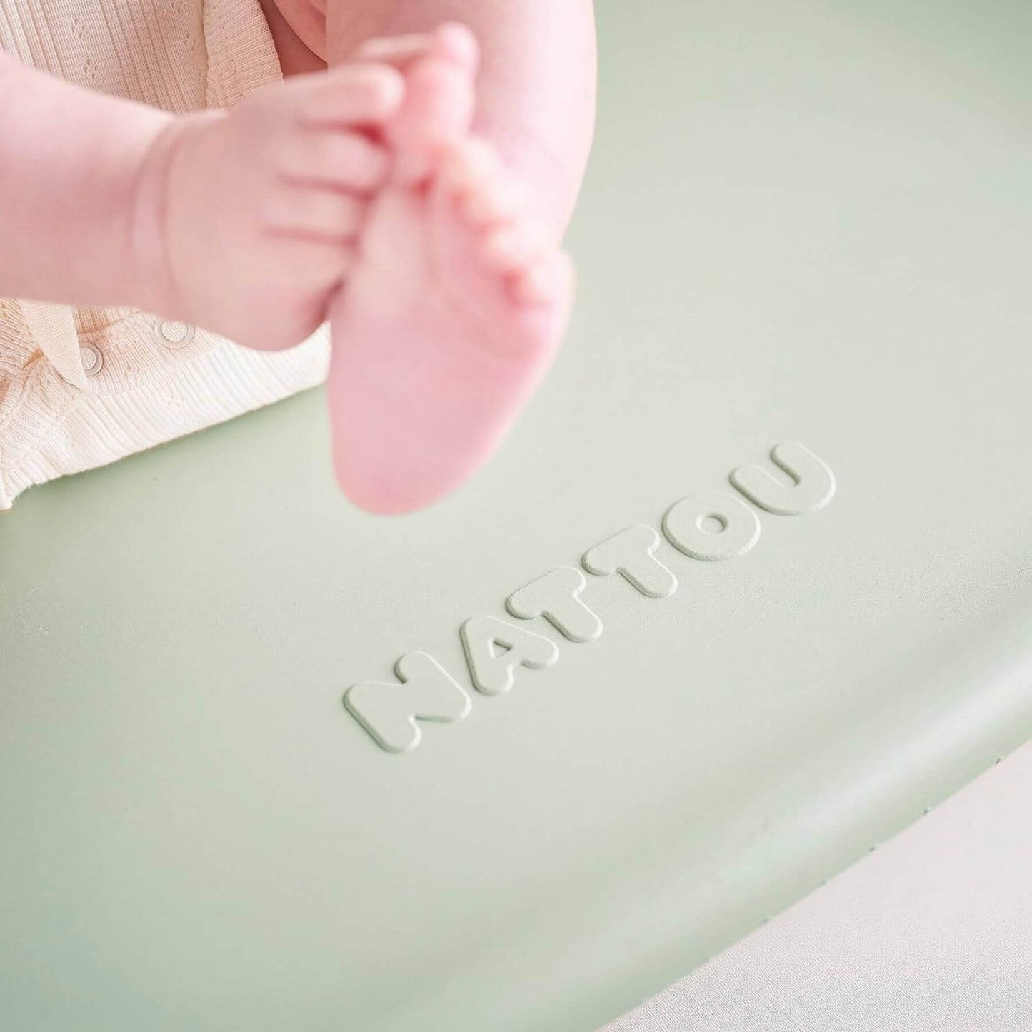 Baby feet on a green Nattou Diaper Changing Pad Softy