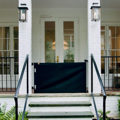 Crafted Gates Co. Oil Waxed Canvas Pet Safety Gate - Black on a white porch with glass doors in the background