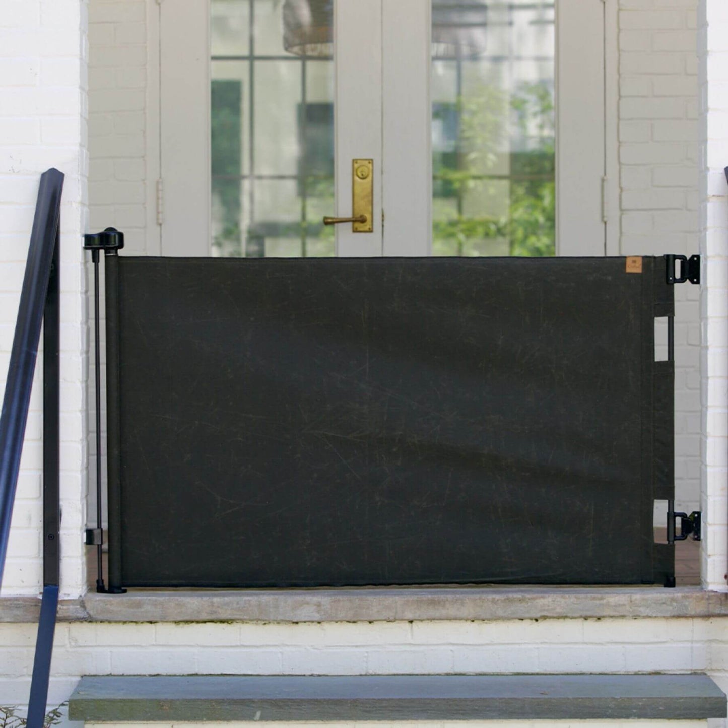 Crafted Gates Co. Oil Waxed Canvas Pet Safety Gate - Olive on a white door with a gold handle