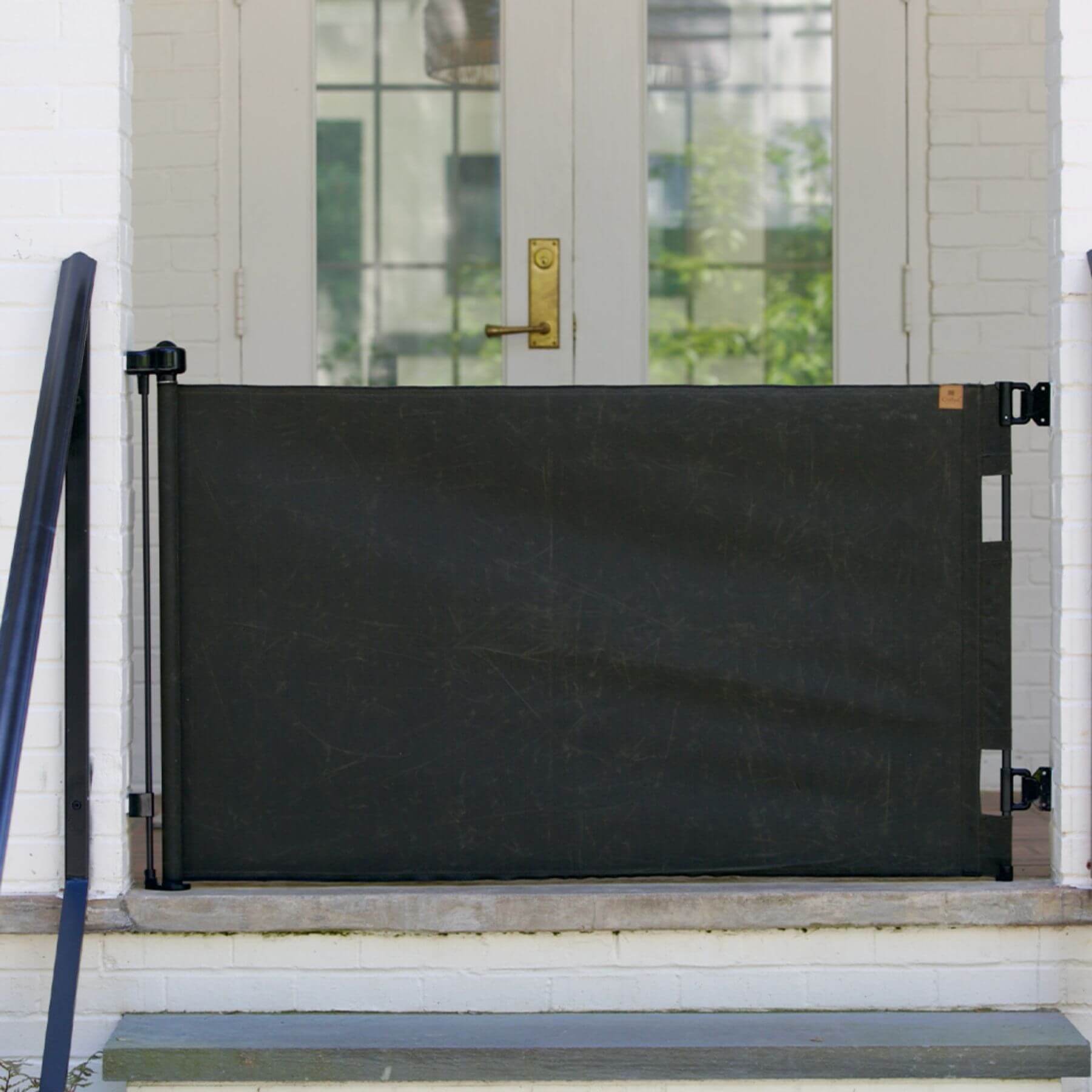 Crafted Gates Co. Oil Waxed Canvas Pet Safety Gate - Olive on a white door with a gold handle