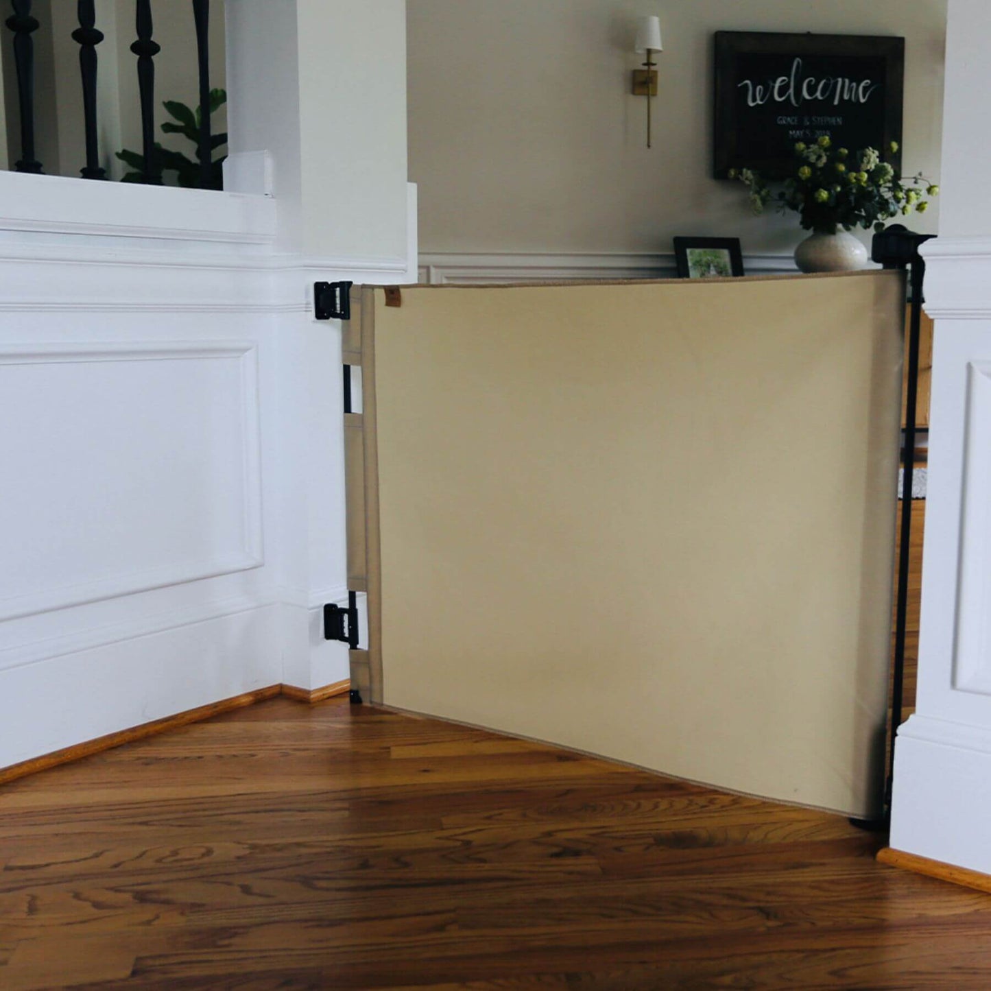 Crafted Gates Co. Oil Waxed Canvas Pet Safety Gate - Sand in a home interior setting with wooden floor and white walls.