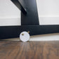 Close-up of Plum+Sparrow Original Rocking Moses Bassinet Stand with brake Black on a wooden floor.